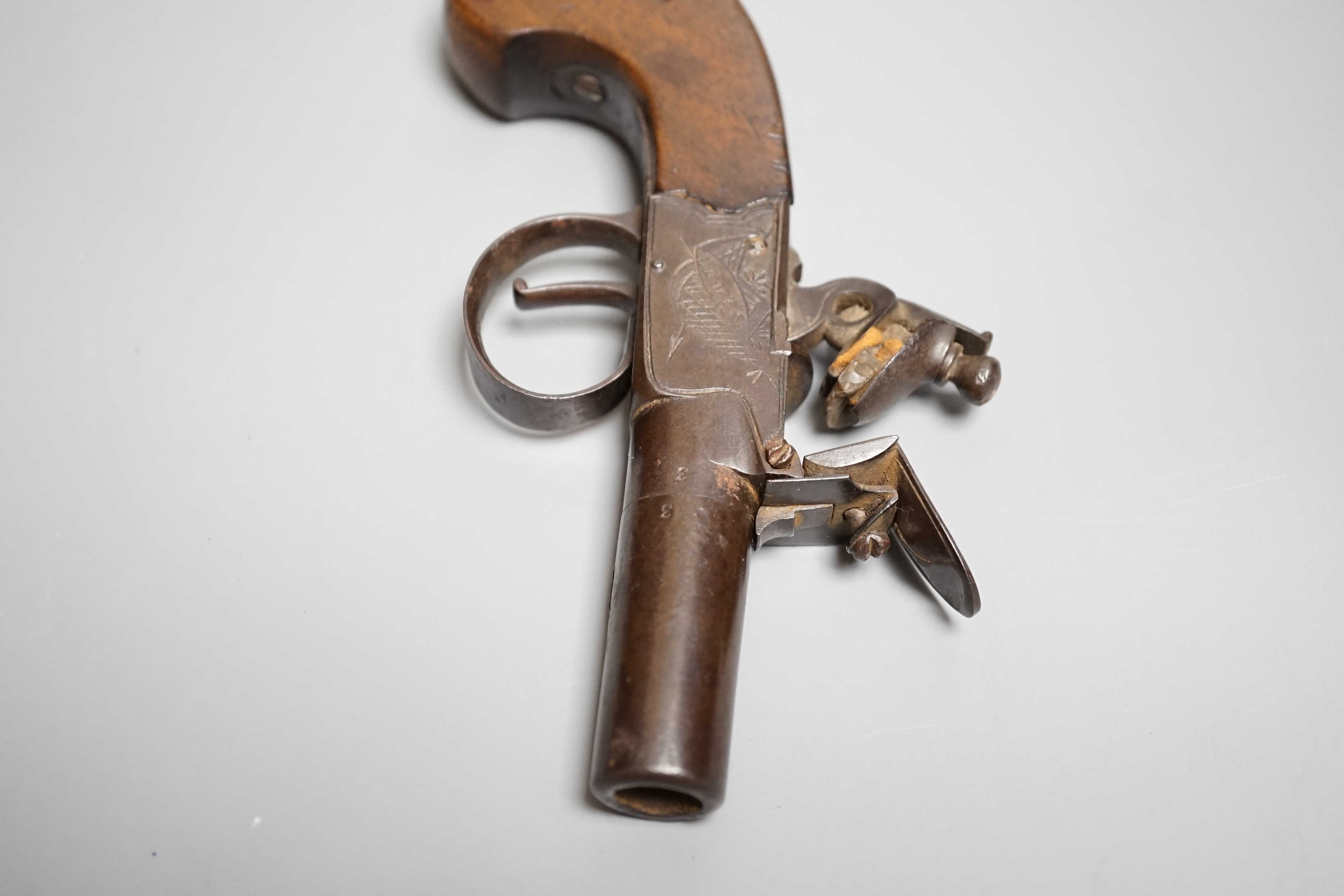 A Flintlock pocket pistol signed Lowdell & Co. Lewes, early 19th century, turn off barrel, signed action engraved with trophies, walnut grip, length 15.5cms